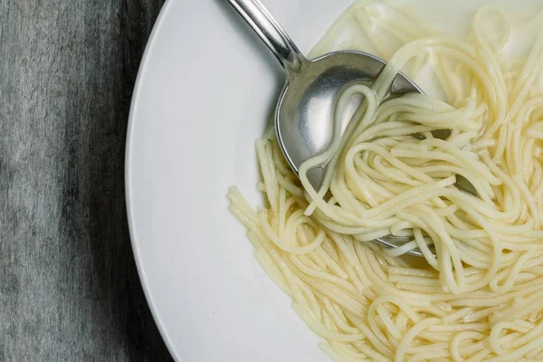 Nagylátószögű közelkép házi készítésű főtt spagetti tejjel fehér tányéron — Stock Fotó