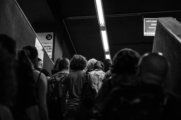 Graustufenaufnahme einer Gruppe von Menschen, die in einer Metrostation gehen — Stockfoto