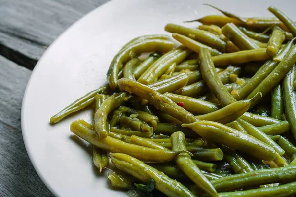 Tiro de alto ángulo de judías verdes hervidas en un plato blanco - perfecto para un artículo sobre comida vegana — Foto de Stock