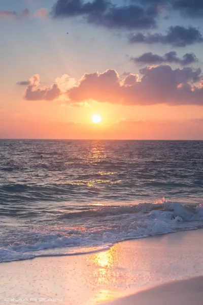 A vertical shot of the sea during golden hour on the beach