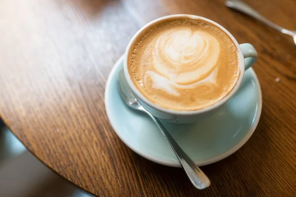 Eine Hochwinkelaufnahme Einer Tasse Cappuccino Auf Einer Holzoberfläche — Stockfoto