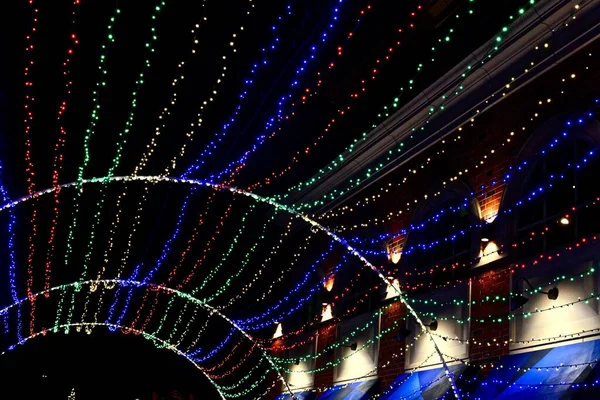 Una Decoración Navideña Con Luces Colores Cerca Edificio Durante Noche — Foto de Stock