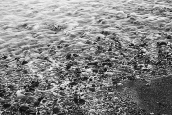 Ein Graustufenfoto Der Bewegung Einer Welle Einem Felsigen Strand — Stockfoto