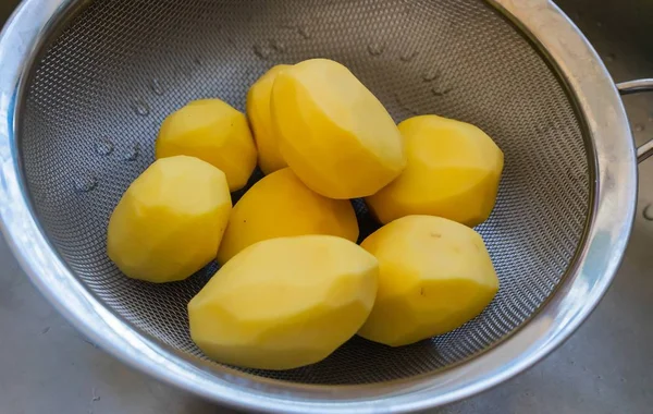Mutfak Lavabosundaki Süzgeçte Soyulmuş Patateslerin Yüksek Açılı Görüntüsü — Stok fotoğraf