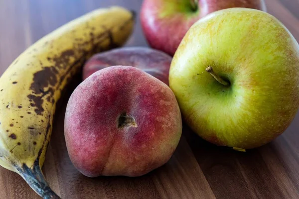 Een Close Shot Van Saturnus Perziken Bananen Appels Een Houten — Stockfoto