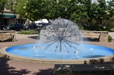 A ball-fountain surrounded by greenery in a park under sunlight in Naperville in Illinois clipart
