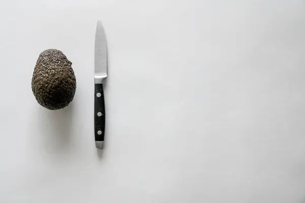 Высокий Угол Съемки Свежего Вкусного Авокадо Ножом Белой Поверхности — стоковое фото
