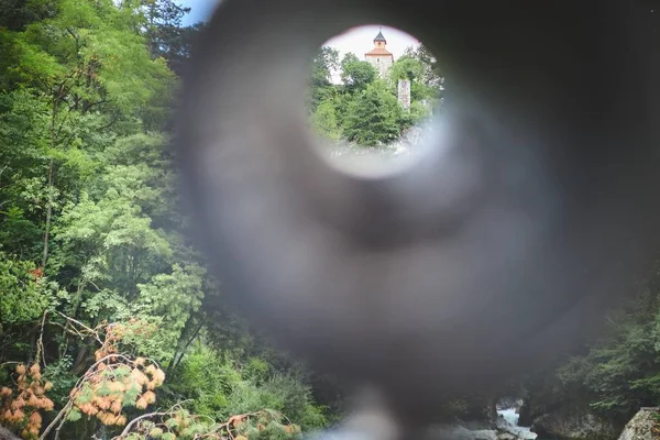 A historical building on top of a hill taken through a hole