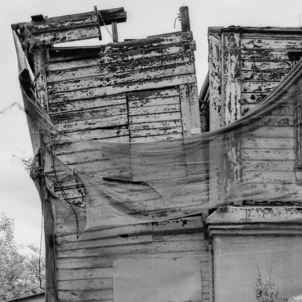 Szare Ujęcie Zrujnowanego Opuszczonego Domu Pokrytego Siatką Zniszczeniu — Zdjęcie stockowe
