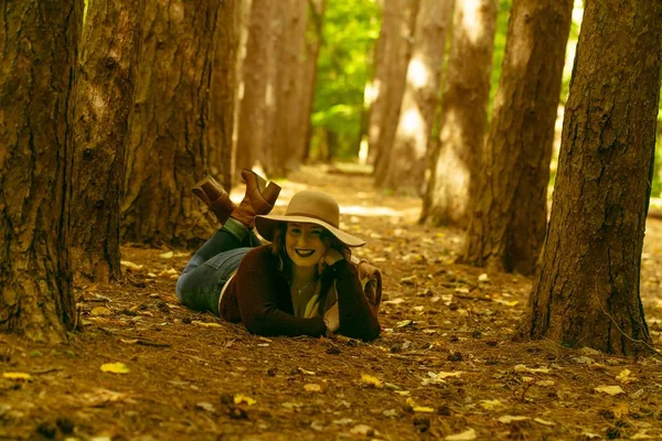 Woman Red Blouse Hat Laying Ground Forest Surrounded Trees Leaves — стоковое фото