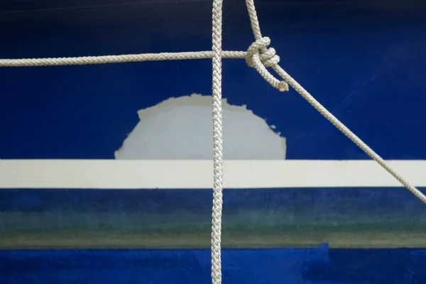 Foto de cierre de cuerdas blancas nupadas delante de una pared azul. — Foto de Stock