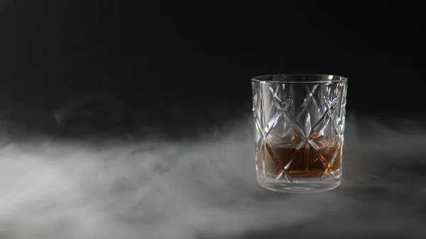 Vaso Whisky Sobre Una Mesa Rodeada Humo Sobre Fondo Negro — Foto de Stock