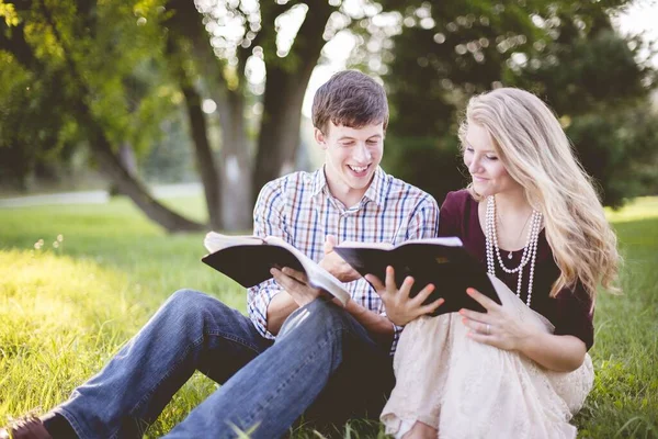 White Christian couple enjoying reading the Bible in the middle of a field — ストック写真