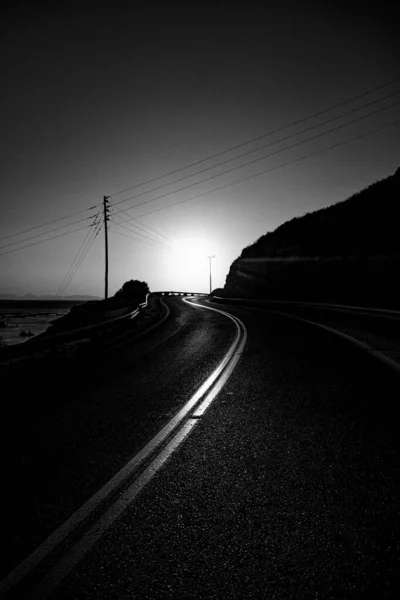 在阳光下被群山环绕的一条弯弯曲曲的路的灰白色鳞片 — 图库照片