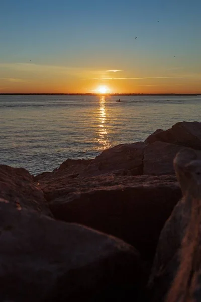 美しい夕日の間に石に囲まれた海と水に反射する太陽 — ストック写真