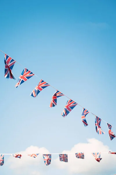 Pionowy Strzał Niskiego Kąta Małych Brytyjskich Flag Kołyszących Się Powietrzu — Zdjęcie stockowe