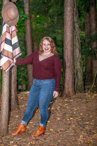 Usmívající Žena Kloboukem Lese Poblíž Stromu Obklopená Větvemi Rozmazaným Pozadím — Stock fotografie