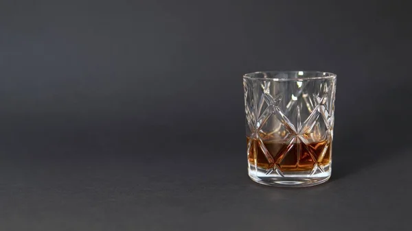 Een Glas Whisky Een Grijze Tafel Tegen Een Wazige Achtergrond — Stockfoto