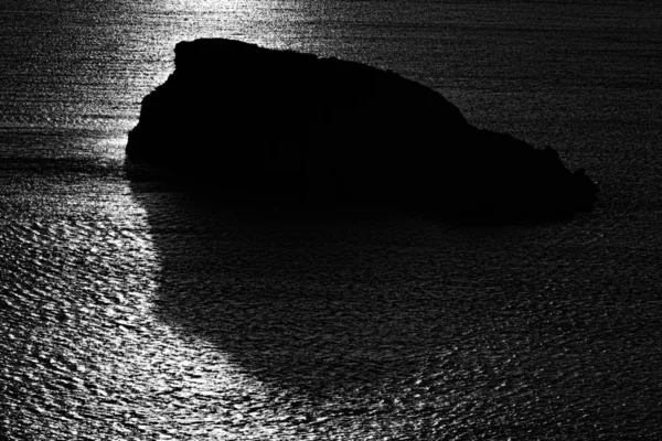 Una Silueta Escala Grises Una Roca Mar Bajo Luz Del — Foto de Stock