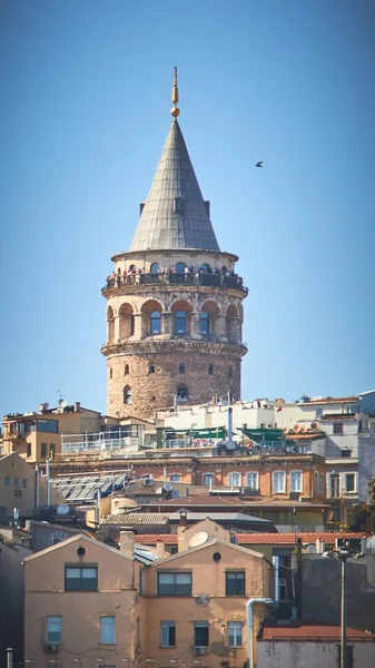 イスタンブール・トルコの距離にあるガラタ塔のある建物の垂直ショット — ストック写真