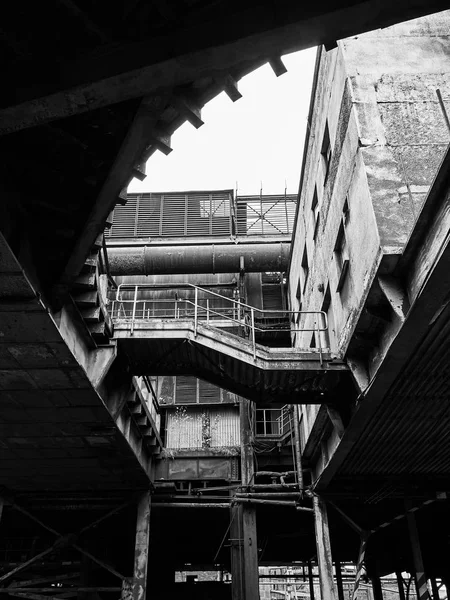 Grayscale vertical tiro de baixo ângulo de um edifício abandonado velho em uma área suburbana — Fotografia de Stock