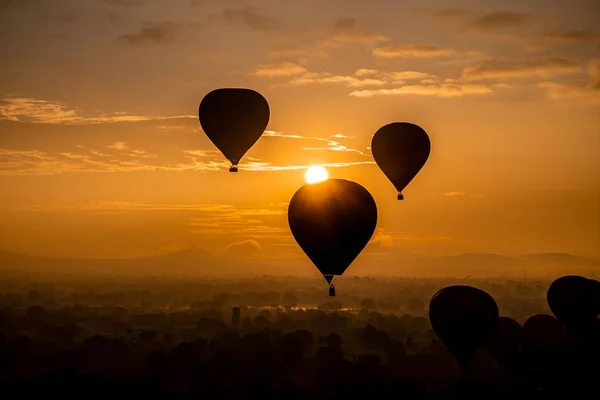 Sylwetka balonów latających w powietrzu z pięknym widokiem na zachód słońca w tle — Zdjęcie stockowe