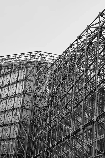 Scatto verticale in scala di grigi della costruzione di un edificio in corso — Foto Stock