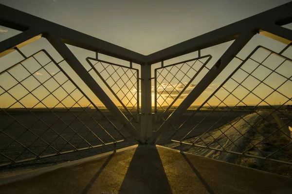 Canto de uma ponte sob o pôr do sol hipnotizante no campo — Fotografia de Stock