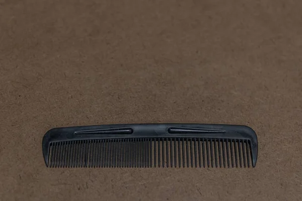 Closeup shot of a hair comb on a brown surface — Stock Photo, Image