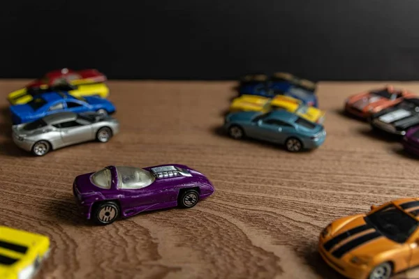 Foco seletivo tiro de um carro esporte roxo brinquedo em uma superfície de madeira — Fotografia de Stock