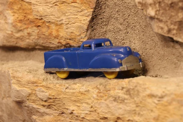 在砂岩边缘拍摄蓝色汽车玩具的特写特写 — 图库照片