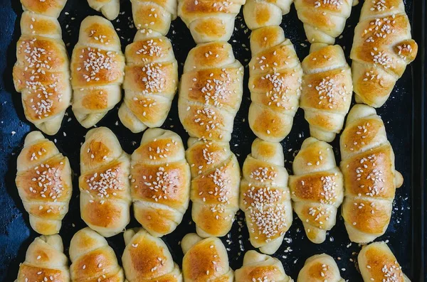 High angle closeup shot of delicious small croissants taken out from the oven — Stock Photo, Image