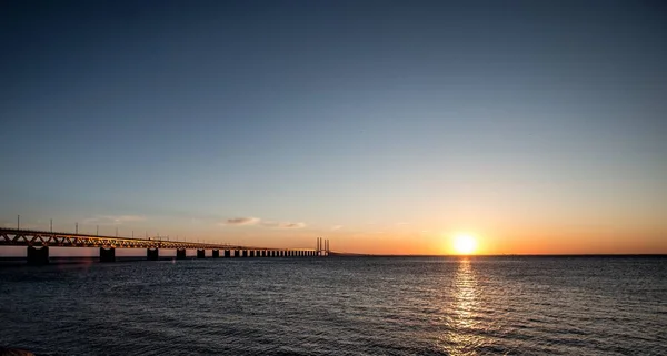 Όμορφη βολή της γέφυρας Όρεσουντ πάνω από τη θάλασσα με τον ήλιο να λάμπει στον ουρανό — Φωτογραφία Αρχείου