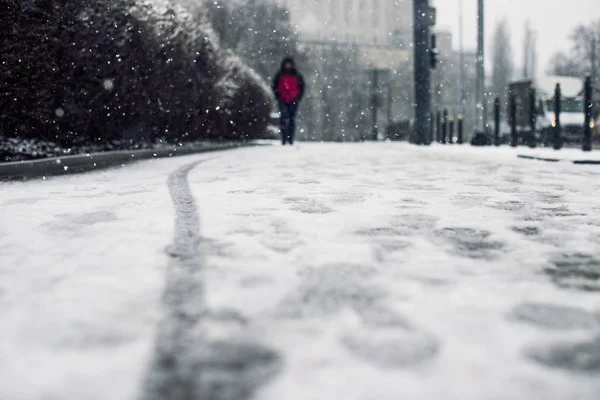 Osoba spacerująca po chodniku pokryta śniegiem z odciskami stóp na śniegu — Zdjęcie stockowe