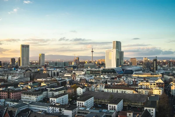 Stad omgeven door moderne gebouwen onder een bewolkte hemel bij zonsondergang — Stockfoto