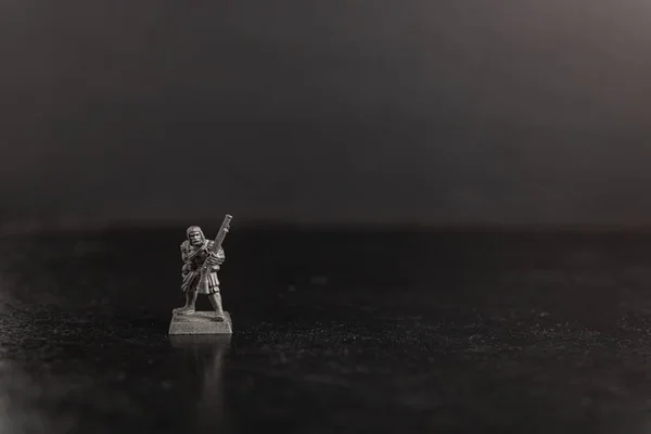 Photo sélective en niveaux de gris d'un soldat tenant une figurine d'arme à feu — Photo