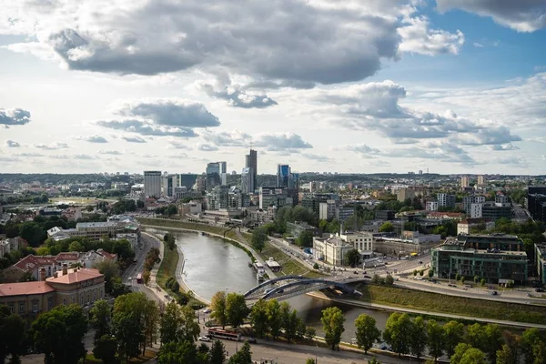 Vilnius city surrounded by buildings and greenery under sunlight and a cloudy sky in Lithuania — Stok fotoğraf