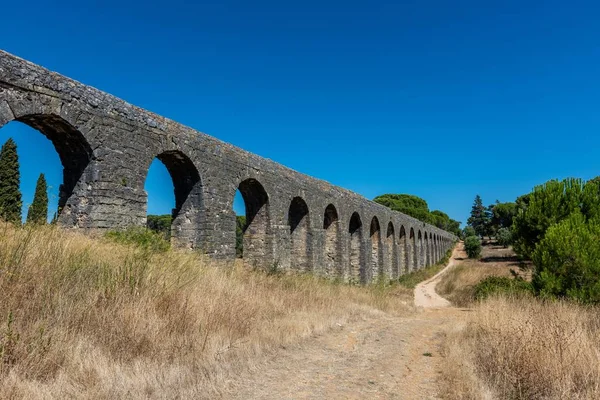 Aqueduto romano de Pego rodeado de vegetação sob a luz do sol em Tomar em Portugal — Fotografia de Stock