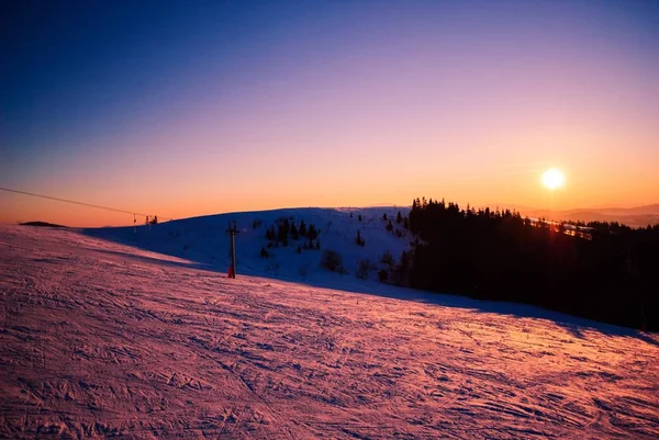 Prachtig uitzicht op een besneeuwde berg terwijl de zon ondergaat — Stockfoto