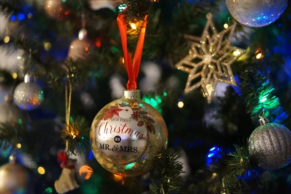 Closeup de decorações de Natal e luzes em uma árvore de Natal com um fundo embaçado — Fotografia de Stock