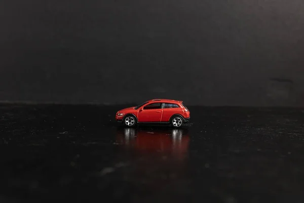 Photographie sélective d'une voiture-jouet rouge sur une surface noire — Photo