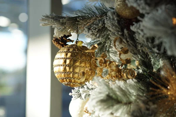 Primer plano de las decoraciones navideñas y luces en un árbol de Navidad con un fondo borroso — Foto de Stock