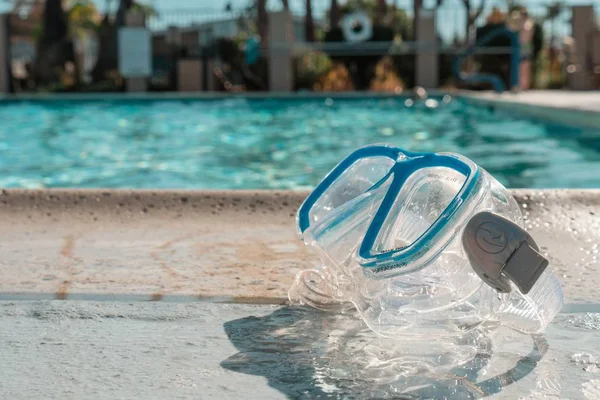 Close-up shot van een zwembril bij een leeg zwembad — Stockfoto