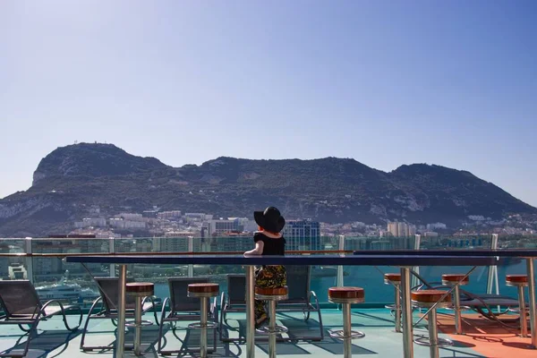 Гарна жінка сидить на веранді і дивиться на океан, захоплений у Гібралтарі. — стокове фото