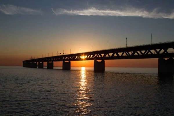 Silhouet van de Öresundsbron brug over het water met de zon op de achtergrond — Stockfoto