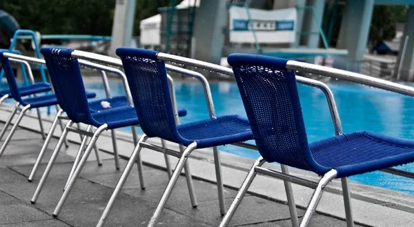 비오는 날 수영장 근처에서 의자에 초점을 맞추어 찍은 선택적 인 사진 — 스톡 사진