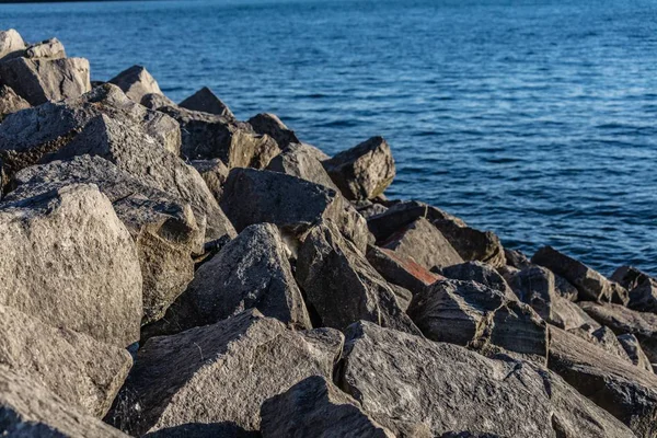 Beautiful shot of a rocky surface on the shore of a sea on a sunny day — Stock Photo, Image