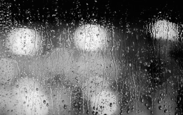 Foto de cierre a escala de rayas de gotas de lluvia en una ventana. — Foto de Stock