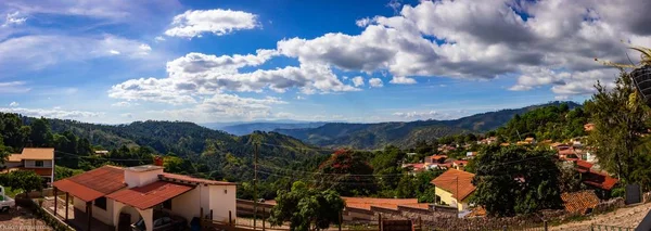Panoramic view of a mountain village under a sunny sky full of clouds — 스톡 사진