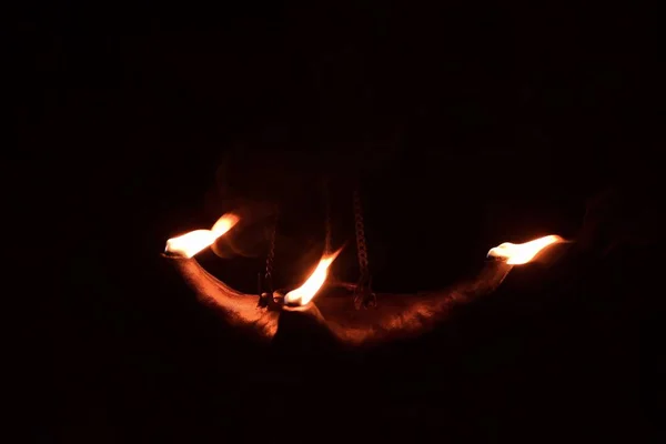 三个火在黑暗中从粘土油灯里喷出 灯是用金属链悬挂的 在马耳他被枪杀 — 图库照片